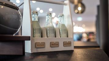 A wooden display case with three glass bottles labeled with different milk types.