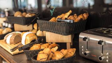 A bakery display with baskets of bread and pastries, a bread slicer, and a toaster.