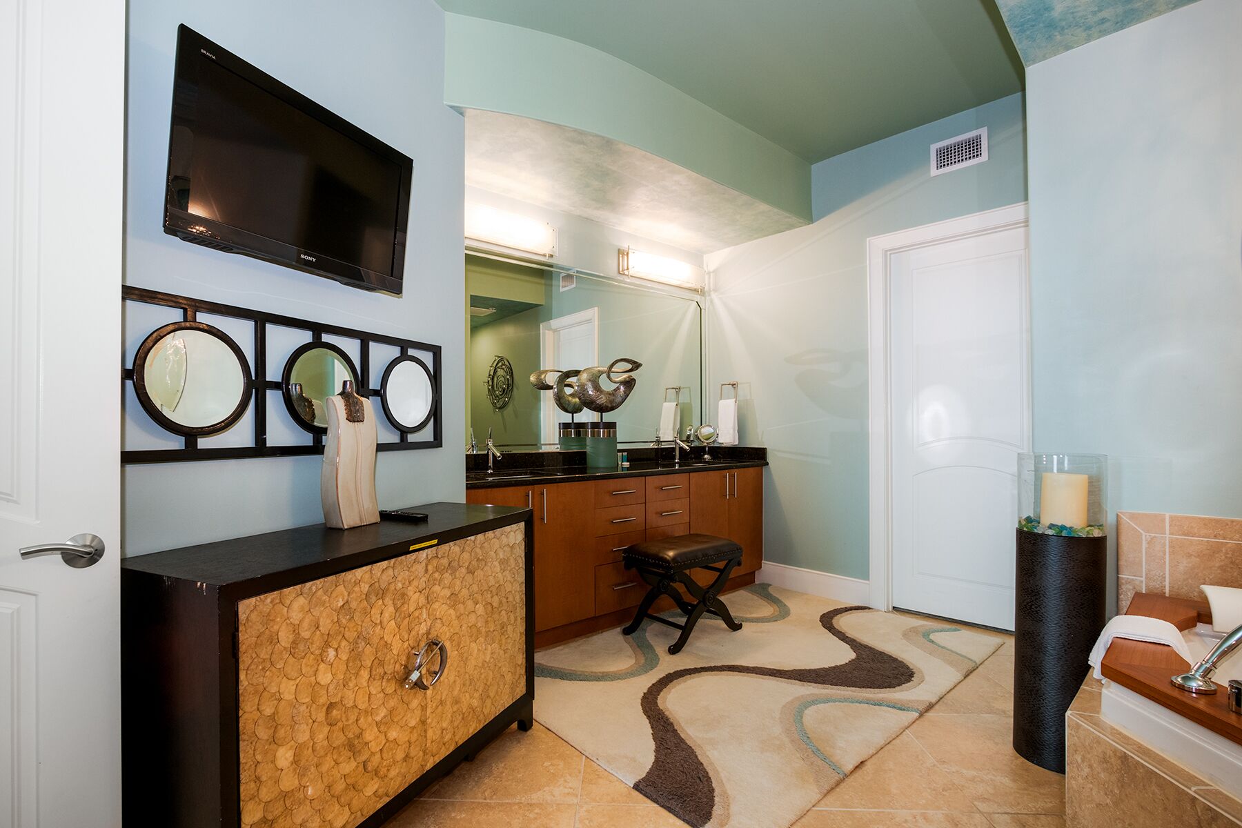 A bathroom with a vanity, a mirror, a sink, and a toilet.