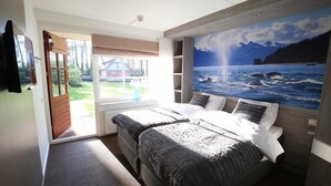 A bedroom with a bed, a window, and a mural of a seascape. - Huize Hölterhof (Enschede)