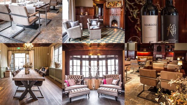 A hotel lobby with a large wooden table, comfortable seating, a fireplace, and a wine bottle. - Huize Hölterhof (Enschede)