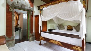 A four-poster bed with a canopy, a wooden bench, a mirror, and a staircase leading to a bathroom. - Pering Bungalow Ubud (Ubud)