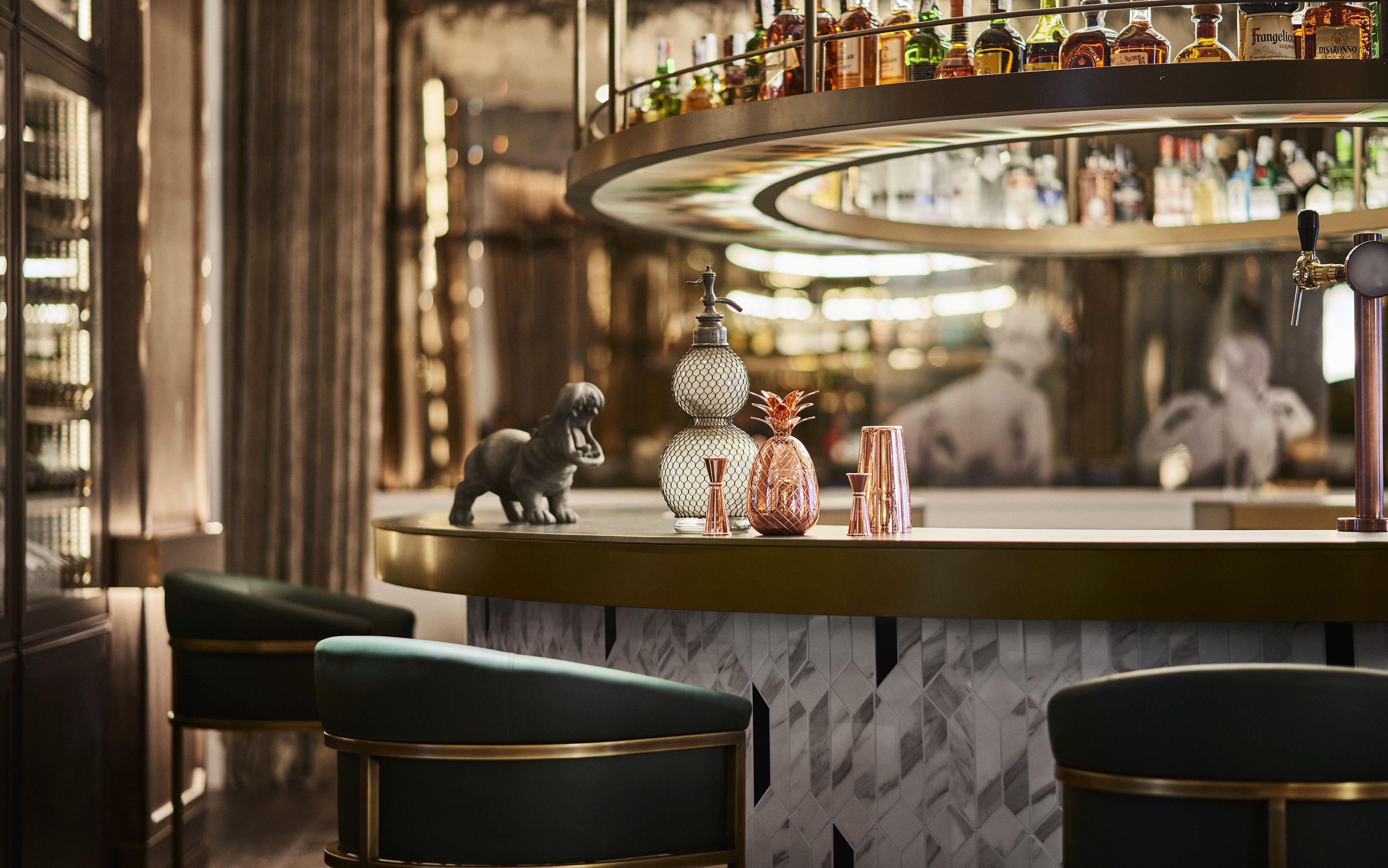 A bar area with a marble countertop, a variety of bottles, and a decorative dog figurine.