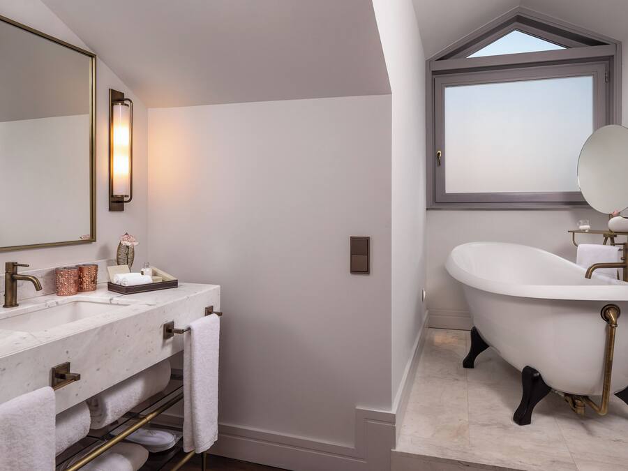 Ein modernes Badezimmer mit einer freistehenden Badewanne, einem großen Spiegel und einem Waschtisch mit Marmorplatte.