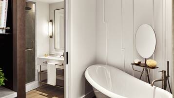 A modern bathroom with a freestanding bathtub, a vanity with a mirror, and a towel rack.