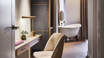 Une salle de bain moderne avec une baignoire, un meuble-lavabo avec un miroir et une chaise.