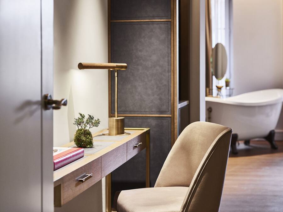 Une salle de bain moderne avec une baignoire, un meuble-lavabo avec un miroir et une chaise.