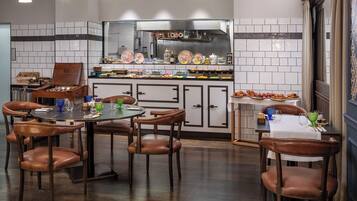 Una cocina moderna con salpicadero de azulejos, una isla central con encimera de madera y un comedor con sillas de cuero marrón y una mesa redonda.