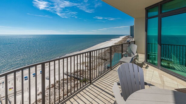 A balcony with a view of the beach and ocean.
