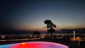 A swimming pool with a sunset view, a palm tree, and a railing. - Relax in our spacious 1400sf 2/2 beach front condo with gorgeous sunset views! (Panama City Beach)