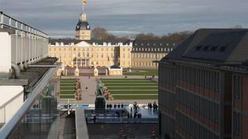 A large, historic building with a prominent tower and a statue in front.