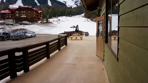 A wooden building with a balcony overlooking a snowy mountain area.