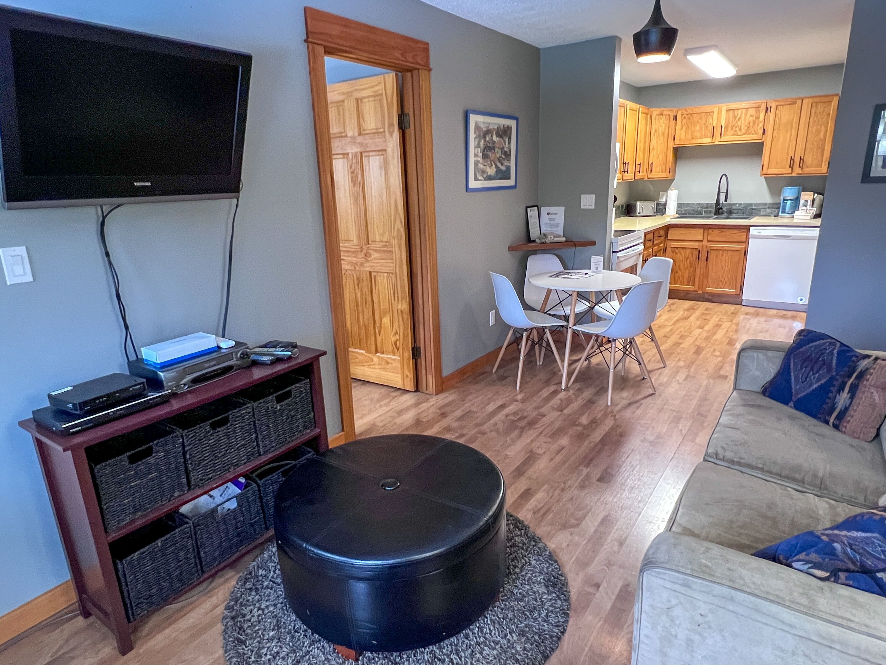 A living room with a TV, a coffee table, a sofa, and a dining area with a table and chairs.