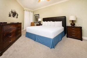 A bedroom with a bed, a dresser, a nightstand, a lamp, and a wall art piece. - ~Beach Front~ Premium 2 Bedroom @ Phoenix IX (Orange Beach)