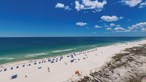 A beach with umbrellas and beach chairs, a sandy shore, and the ocean. - Gulf Breezes & Ocean Blues 2 Bedroom Phoenix X 1416 (Orange Beach)