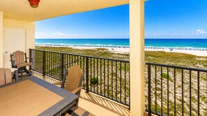 A balcony with a view of a beach and ocean.