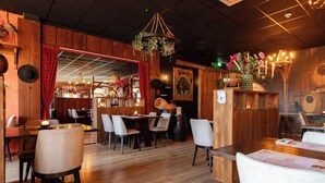 L’intérieur d’un restaurant avec des murs en bois, de nombreuses tables et des chaises.