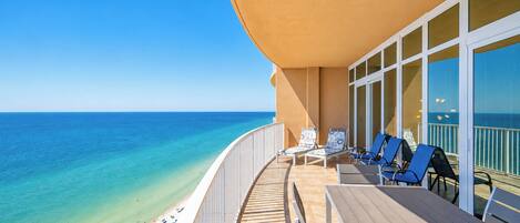 A deck with lounge chairs and a view of the ocean.
