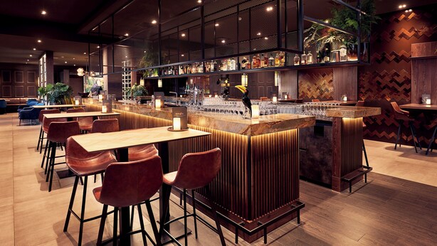 A modern bar area with a bar counter, seating, and ambient lighting. - Van der Valk Hotel Leeuwarden (Leeuwarden)