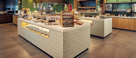 A modern breakfast bar with a variety of food items and a coffee station.