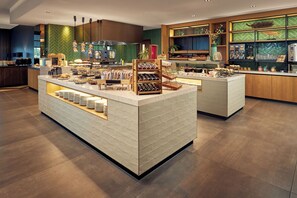 Una barra de desayuno moderna con una variedad de alimentos y una estación de café.