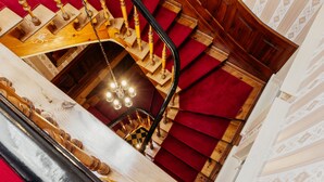 A grand staircase with a wooden handrail and a chandelier. - Hotel und Restaurant Deutscher Kaiser (Perleberg)
