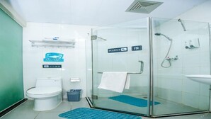 A modern bathroom with a glass shower enclosure, a white toilet, and a blue mat on the floor. - 7 Days Inn (Tianjin)