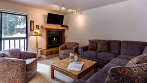 A cozy living room with a fireplace, patterned furniture, and a television. - Frisco - Sleeps 10. Best value in Frisco! 2 blocks to Main St, 10 min to Copper. (Frisco)