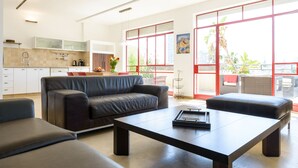 Una sala de estar moderna con un sofá, una mesa de centro y un comedor con una mesa y sillas.