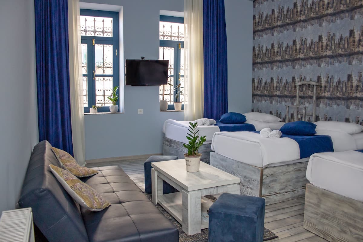 A modern living room with a sofa, a coffee table, and a TV mounted on the wall.