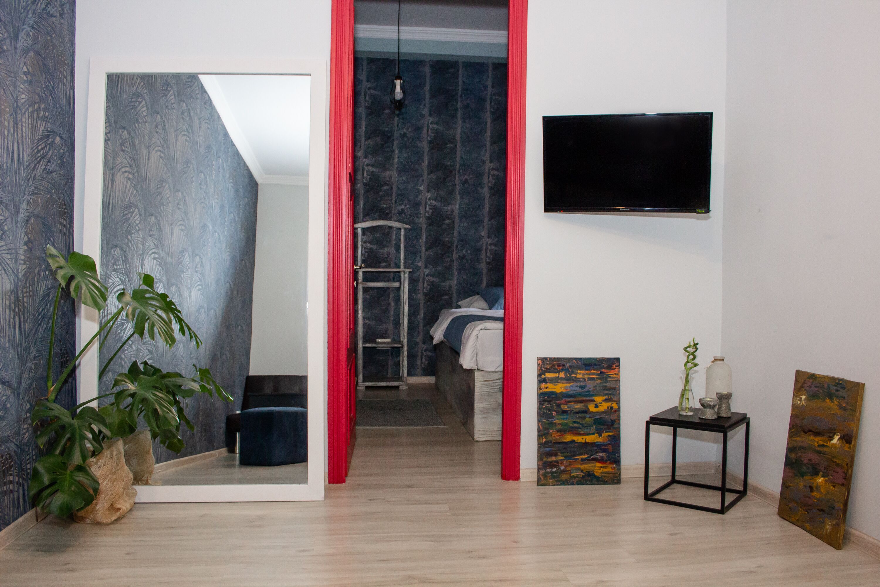 Una habitación moderna con una cama, un televisor y obras de arte en las paredes.