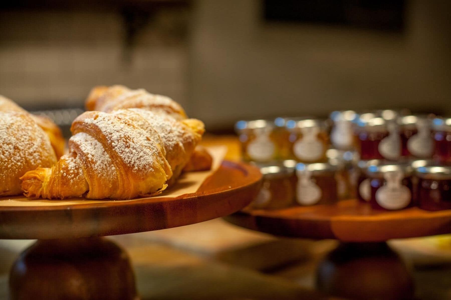 Des pâtisseries présentées sur des présentoirs en bois, avec un arrière-plan flou.