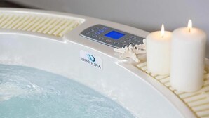 A hot tub with a control panel and two lit candles. - Villa Stella Maris (Budoni)