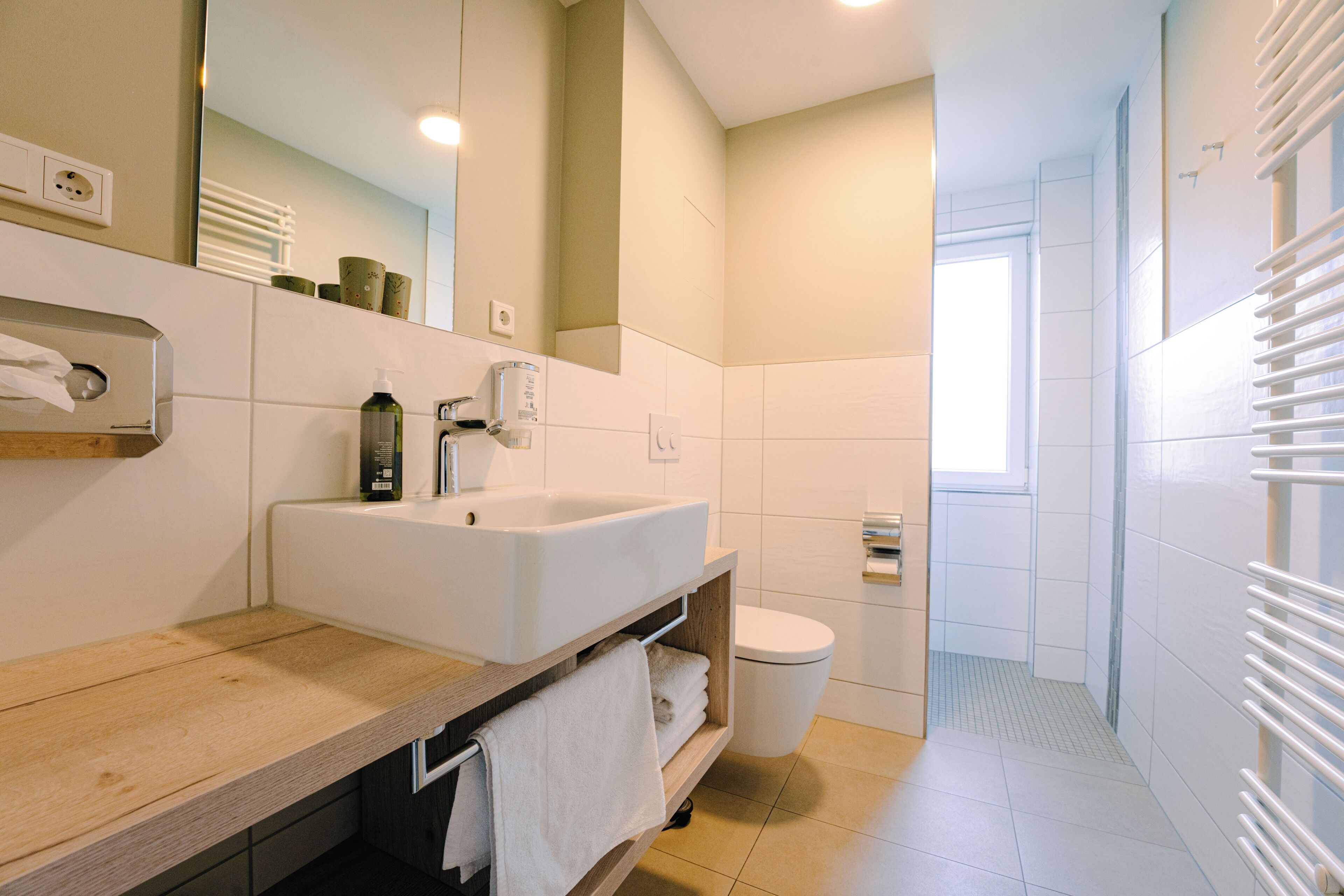 Une salle de bain moderne avec un lavabo, un miroir et des toilettes.