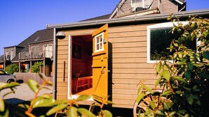 A wooden house with an open door, a window, and a visible balcony. - Waastwinj (Utersum)