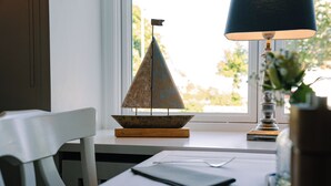 A table with a small decorative boat, a lamp, and a vase with flowers. - Waastwinj (Utersum)
