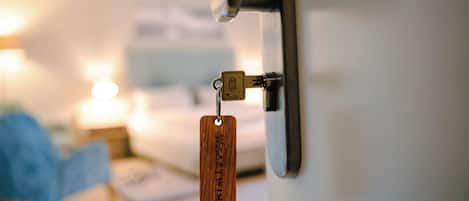 A door lock with a key and a wooden keychain.