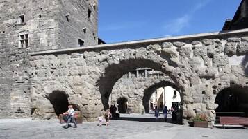 Un arco de piedra que conduce a un edificio histórico con una torre.