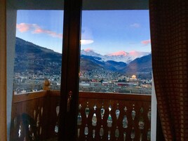 Un balcón con vistas a un paisaje montañoso y una ciudad en la distancia.