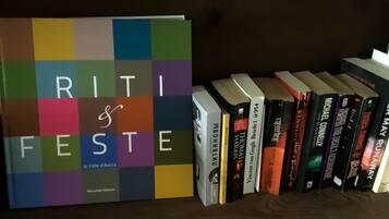 A bookshelf with a colorful book titled "RITI & FESTE" and several other books.