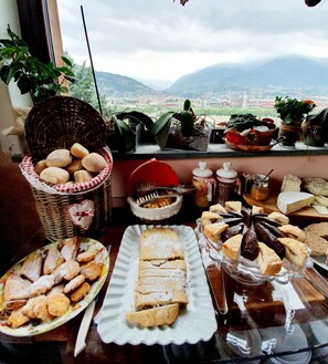 A table with various pastries and bread, a wicker basket, and jars of condiments. - Agriturismo Chevres a Cheval (Charvensod)