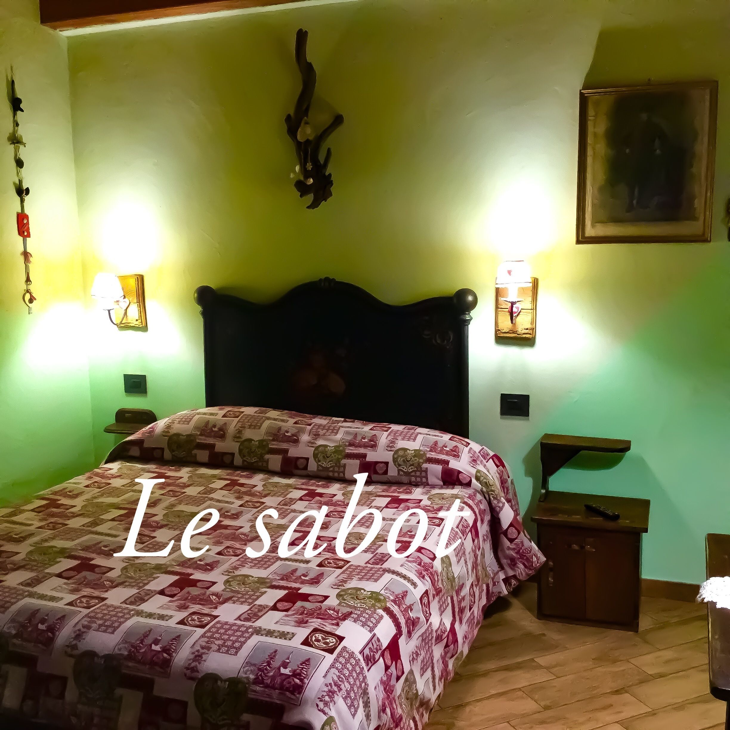 A bedroom with a bed, two wall-mounted lamps, a painting, and a wooden headboard.