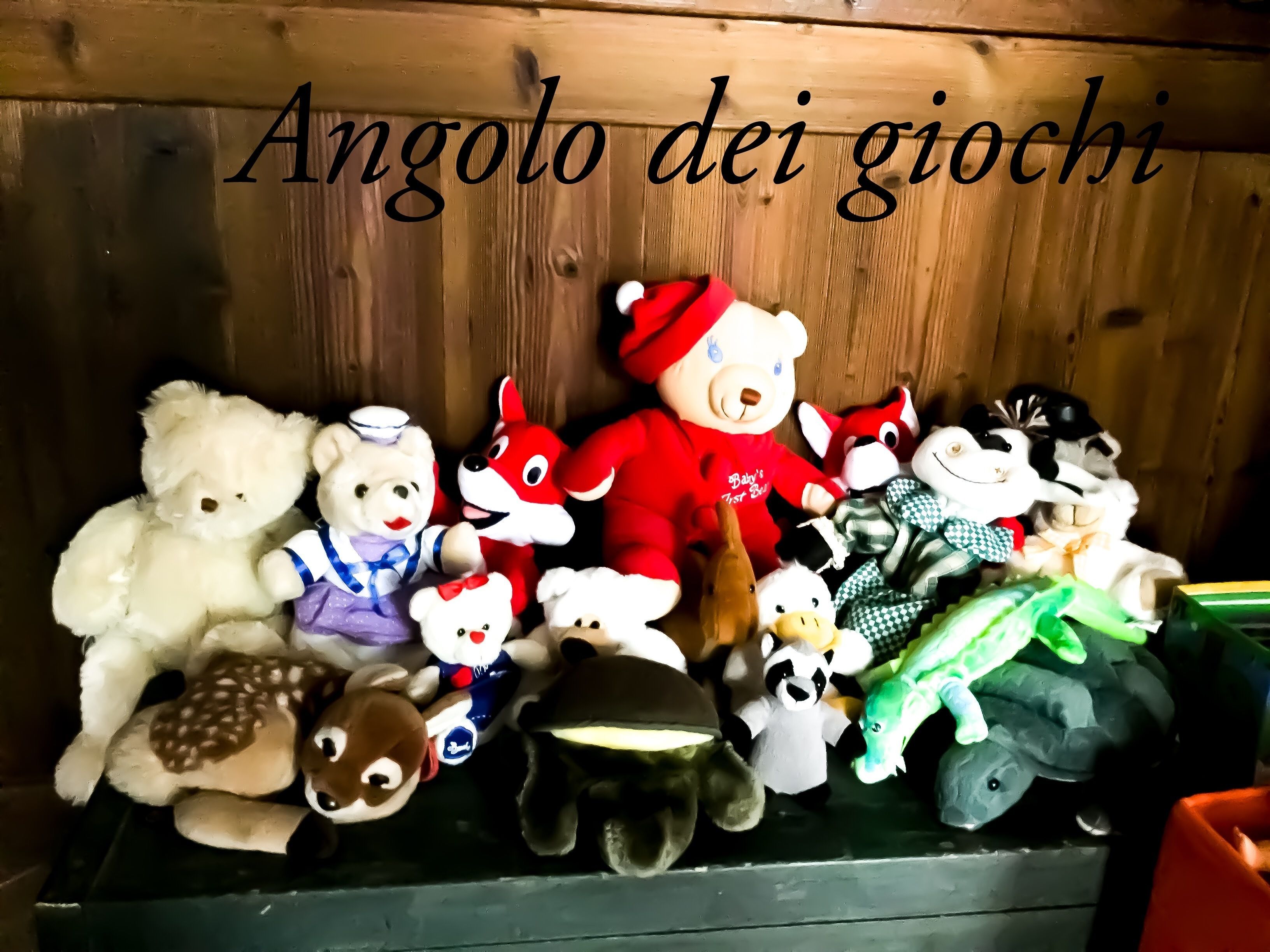 A collection of stuffed toys arranged on a shelf against a wooden backdrop.