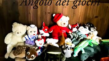 A collection of stuffed toys arranged on a shelf against a wooden backdrop.