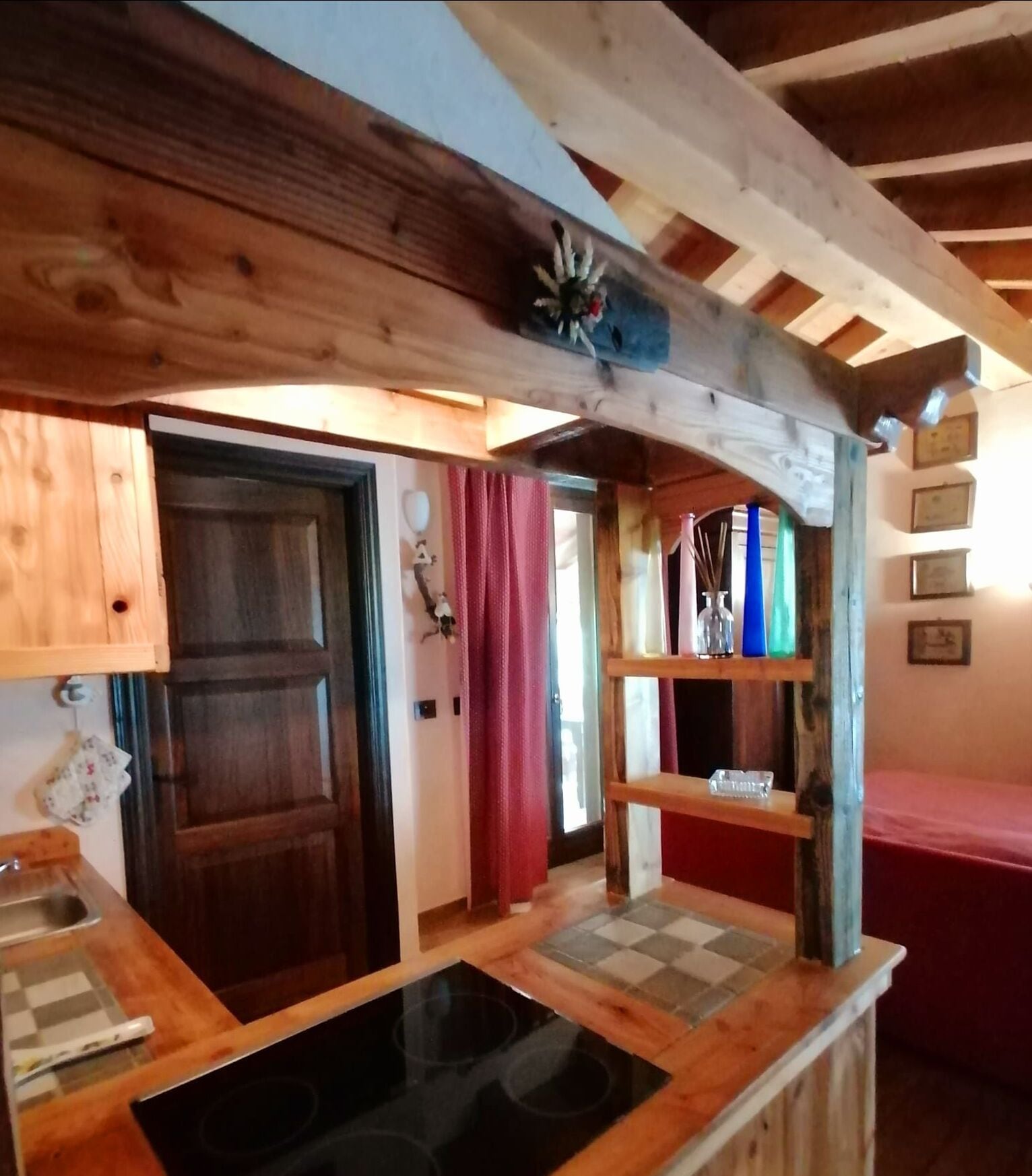 Una cocina rústica con vigas de madera, salpicadero a cuadros y encimera de madera.