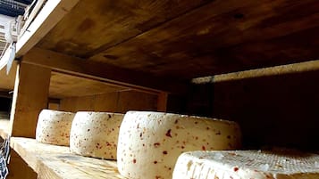 A wooden shelf with several blocks of cheese.
