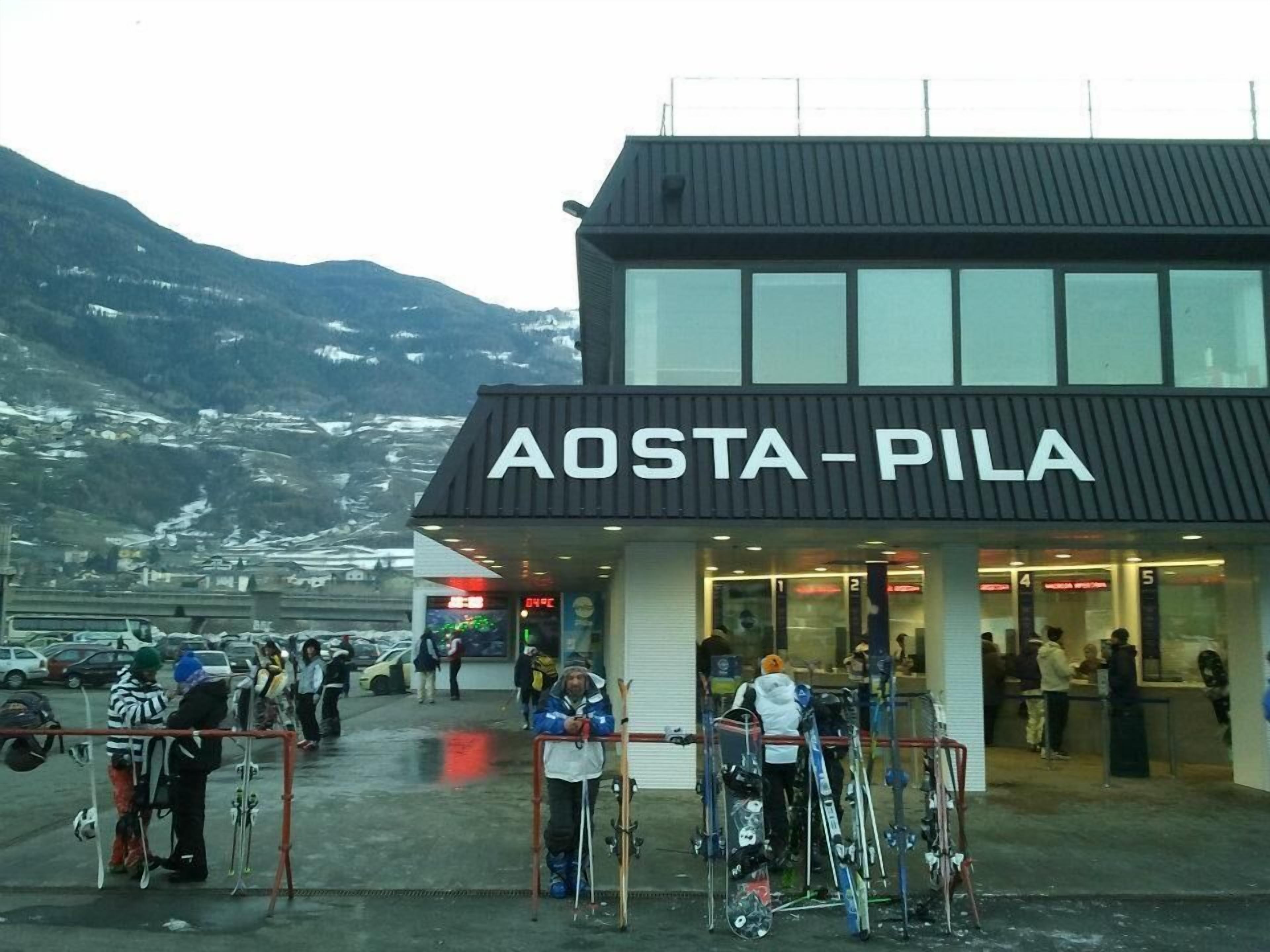 Un edificio con el cartel 'AOSTA-PILA' que indica una estación de esquí.