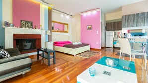 Una habitación de hotel moderna con cama, sofá, mesa de comedor y área de cocina.