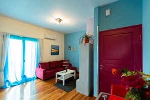 Apartamento família, vista para a montanha | Área de estar | TV de plasma