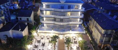 Vista frontal de la propiedad por la tarde o noche